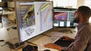 A man sits at his desk mapping out Drone and Aerial Surveys